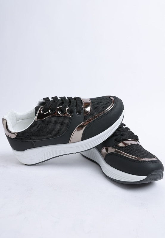 Black and white sneakers with metallic accents on a light gray background