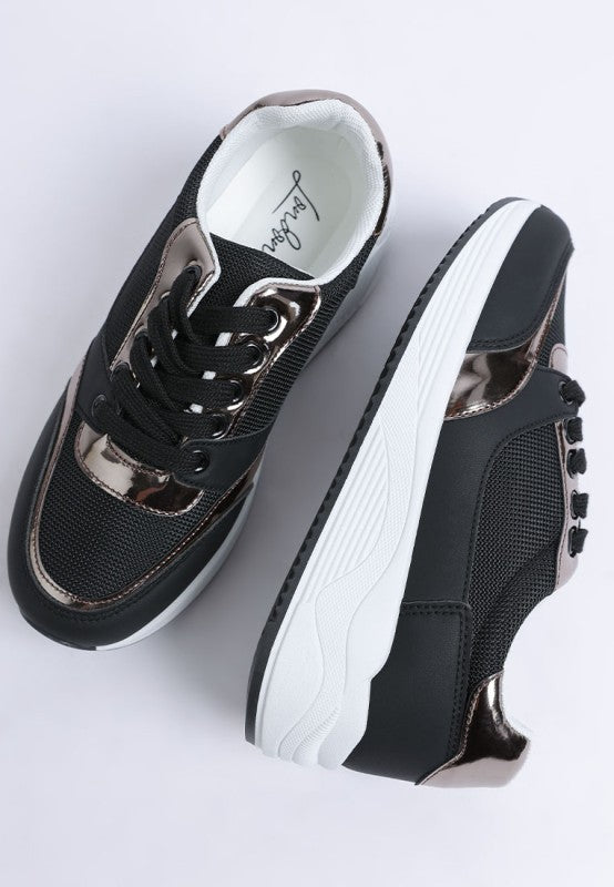 Black and white sneakers with metallic accents on a light gray background