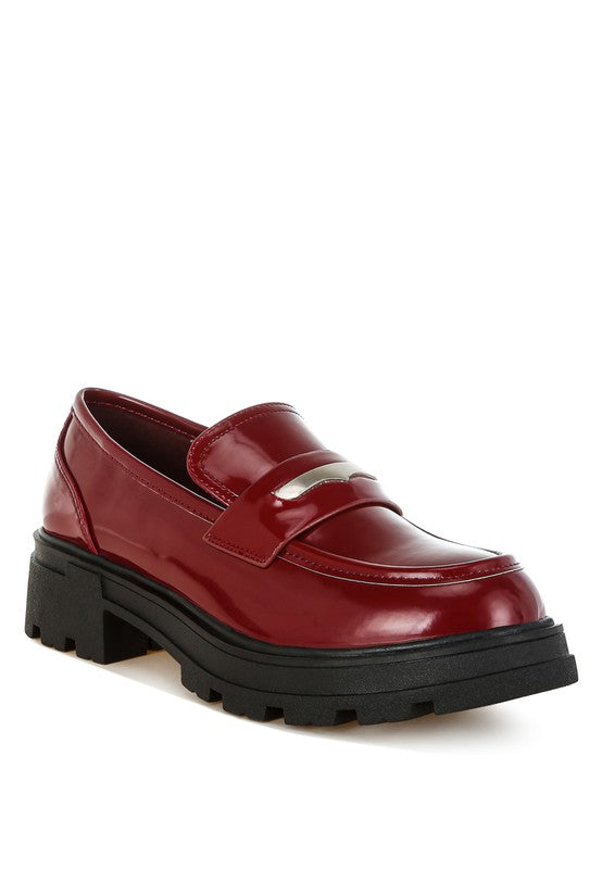 Red loafer shoe with a thick black sole on a white background
