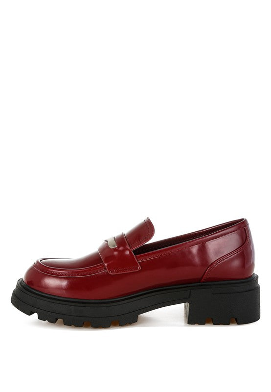 Red loafer shoe with a thick black sole on a white background