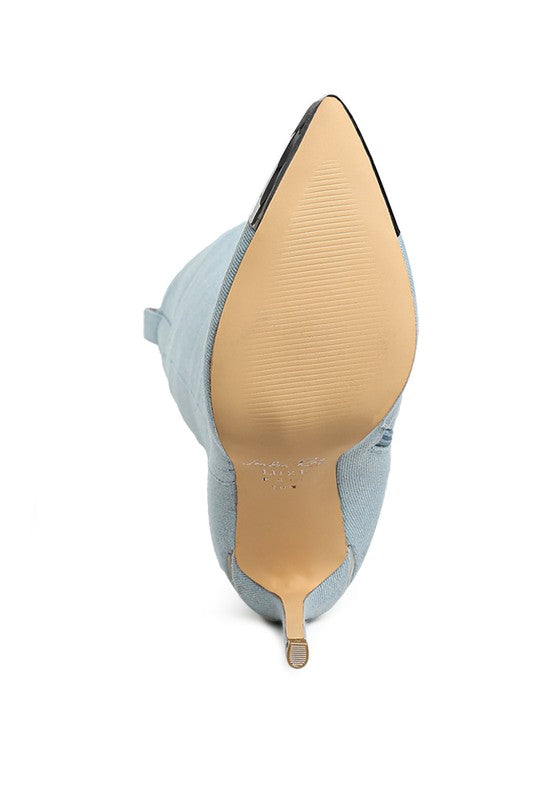 Close-up of a pointed-toe shoe with a light blue heel and beige insole on a white background.