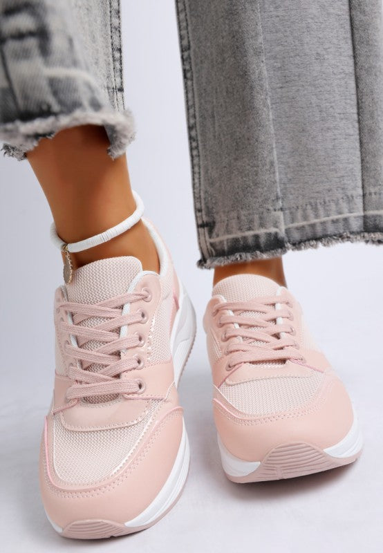 Pink sneakers worn with gray jeans on a light background