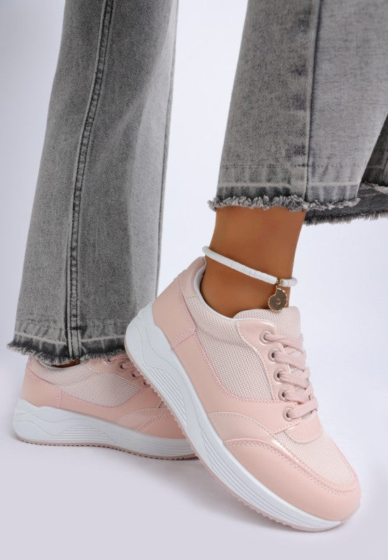 Pink sneakers worn with gray jeans on a light background