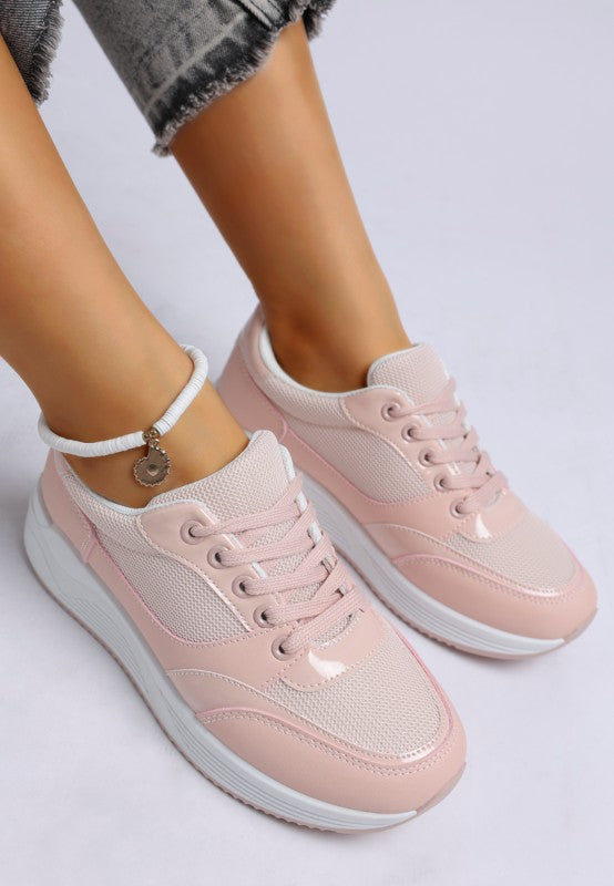 Pink sneakers worn with light gray pants on a white background
