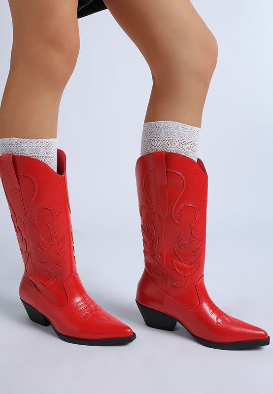 Red cowboy boots worn with white socks on a light gray background
