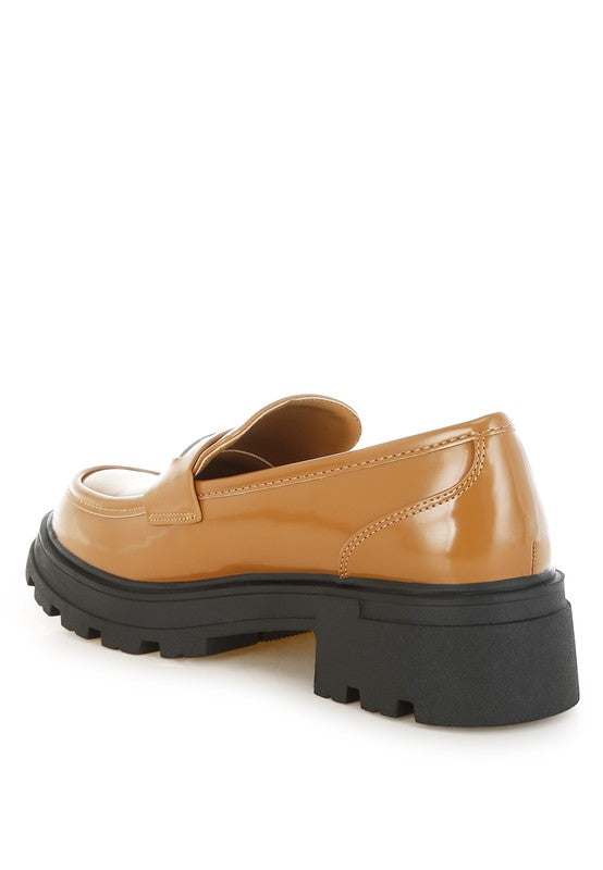 Tan loafers with black sole on a white background