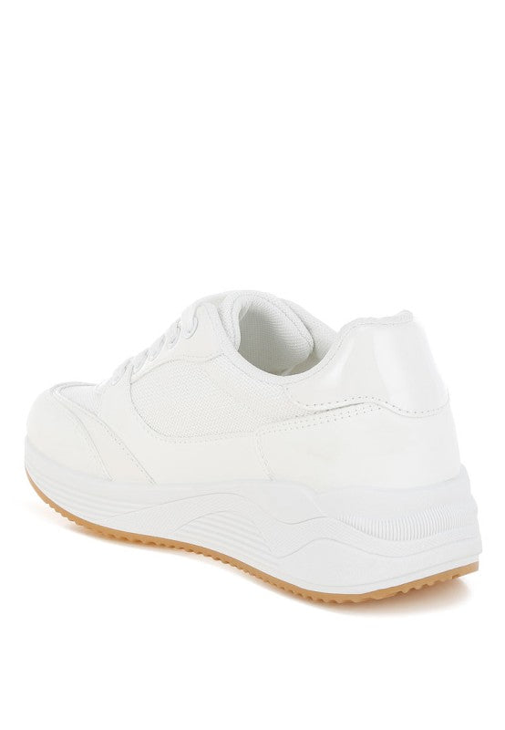 White sneaker with a brown sole on a white background