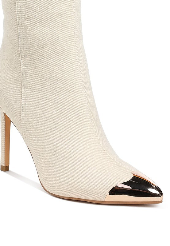 Beige sock boot with black pointed toe on a white background