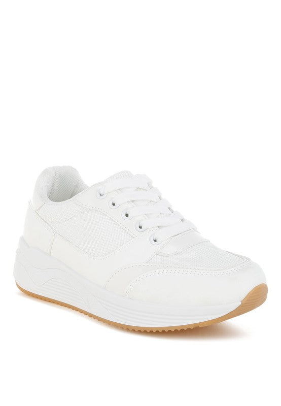 White sneaker with a light brown sole on a white background